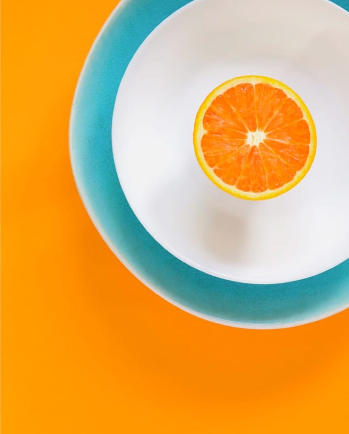 half cut orange on a white plate